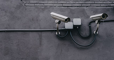 Two security cameras fixed to a wall.