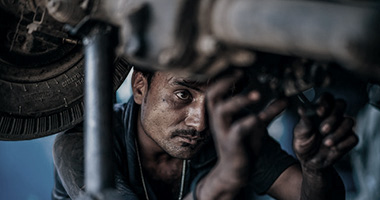 A mechanic working under a vehicle.
